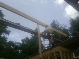 Carpenter setting a ridge beam over a new addition frame — Ice Dam Removal by Roofing Brothers in Clark