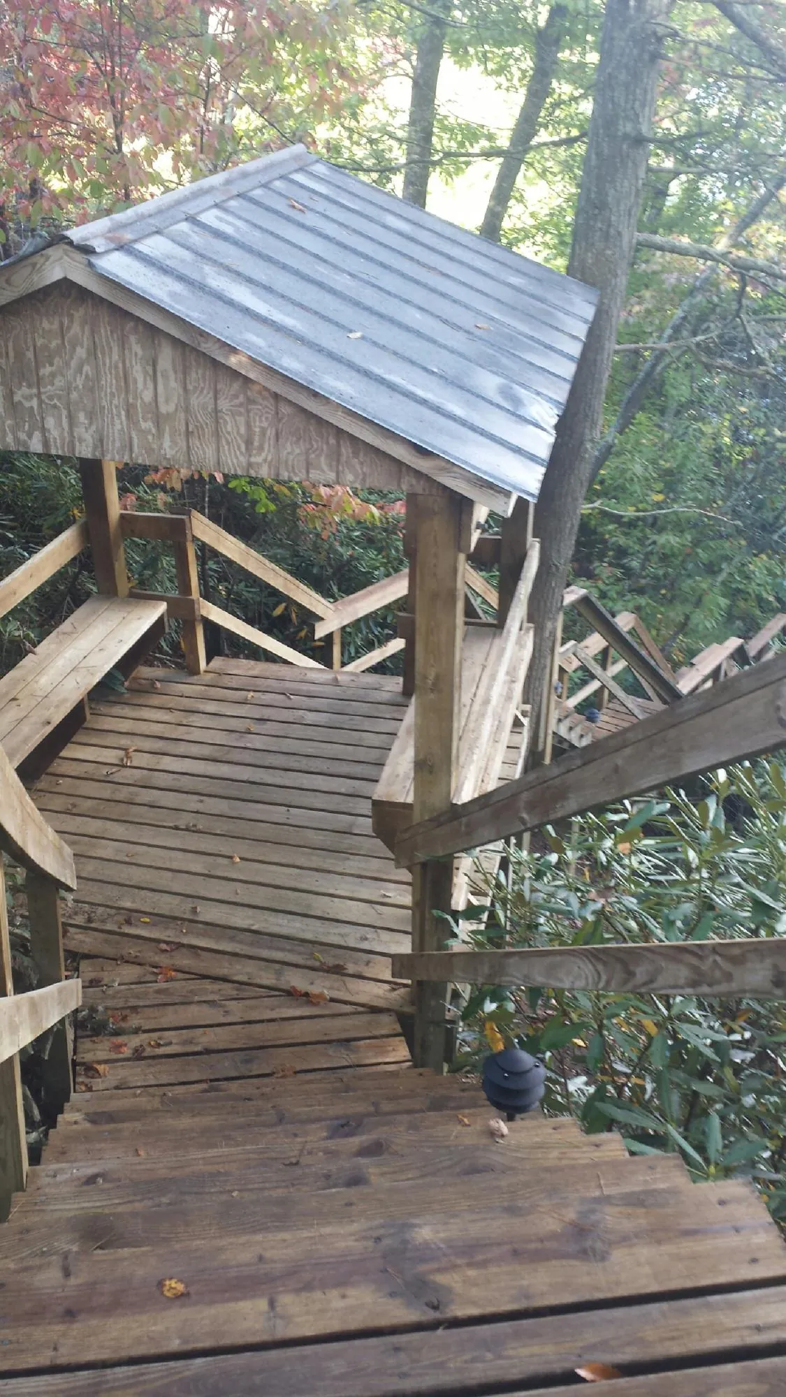 Metal roofed shelter over wooden steps on a wooded walkway — Skylight Repair & Installation work by our crew in Clark