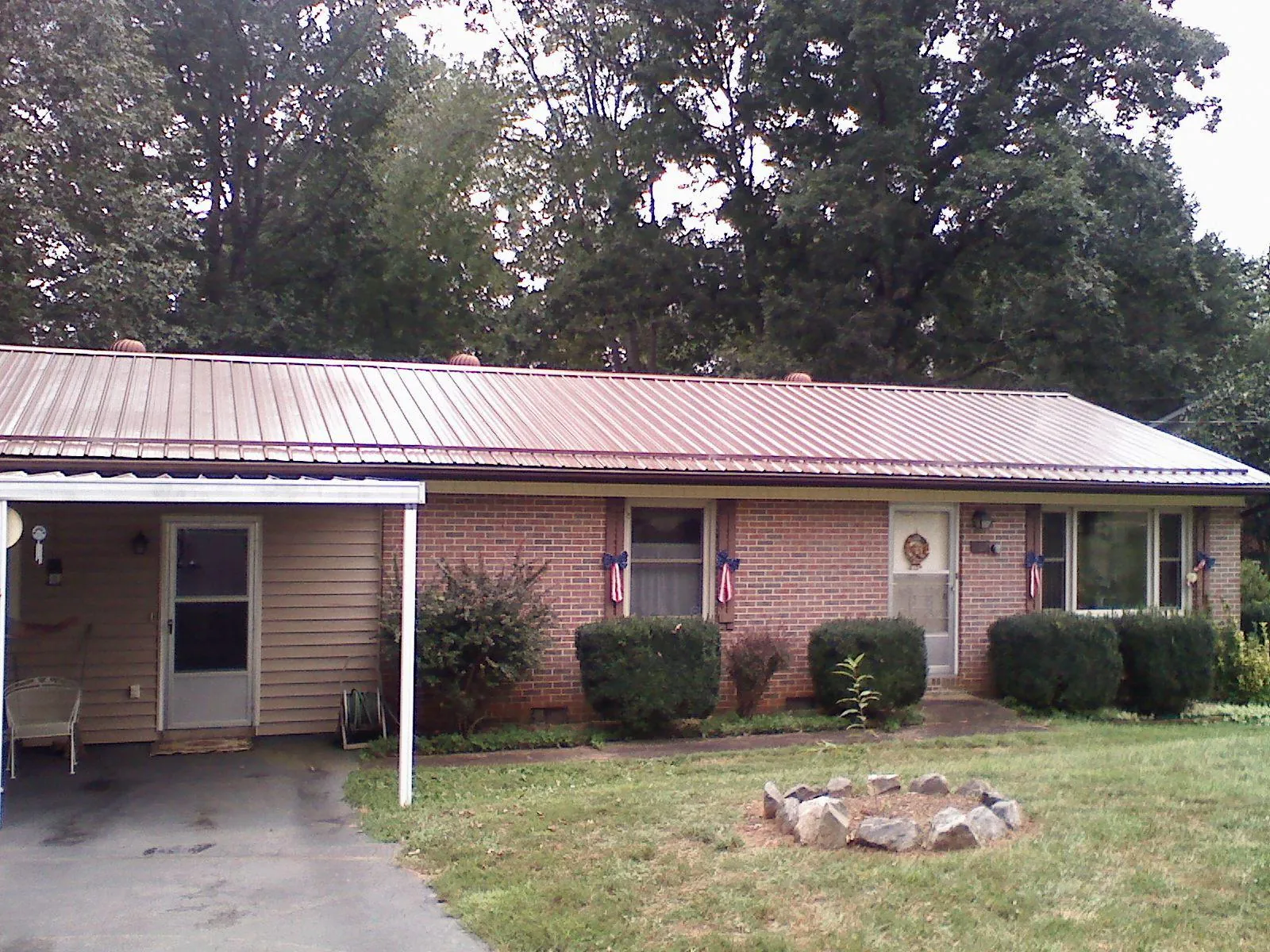 Bronze metal roof and carport on a brick ranch home — Roof Repair work by our crew in Clark
